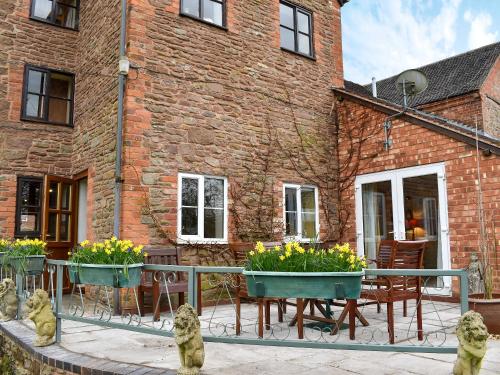 a patio with tables and chairs and a brick building at Cider Mill in Berrington
