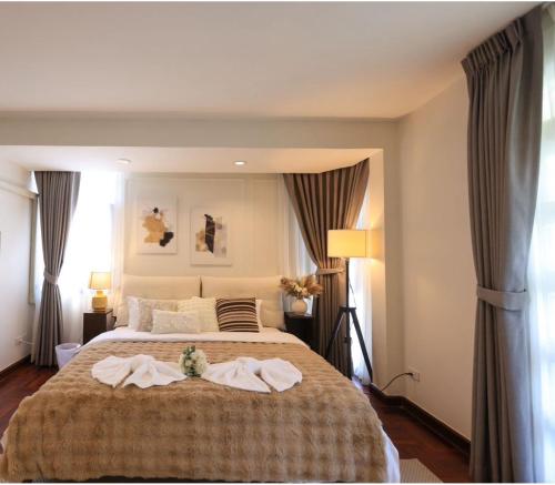 a bedroom with a large bed with two towels on it at Private Pool Villas Sukhumvit 26 Near BTS Phrom Phong and EmSphere in Bangkok