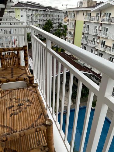 a balcony with two chairs and a view of buildings at Cozy Staycation Near Cebu Airport with Pool & Gym , Free Wifi in Pusok