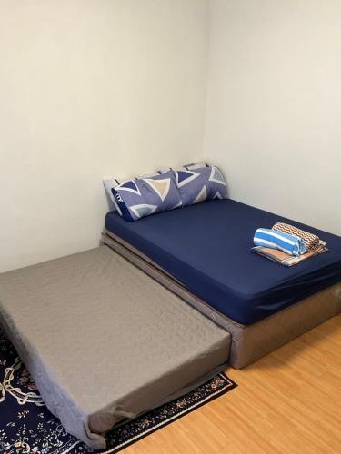 a bed with blue sheets and pillows on top of it at Cozy Staycation Near Cebu Airport with Pool & Gym , Free Wifi in Pusok