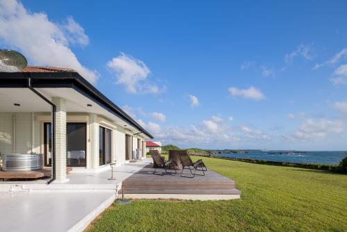 a house with a deck with a view of the ocean at Daddy&Mommy in Miyako-jima