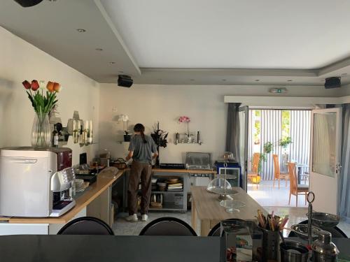 a man standing in a kitchen with a counter at Alkyonides Boutique Hotel in Kremasti