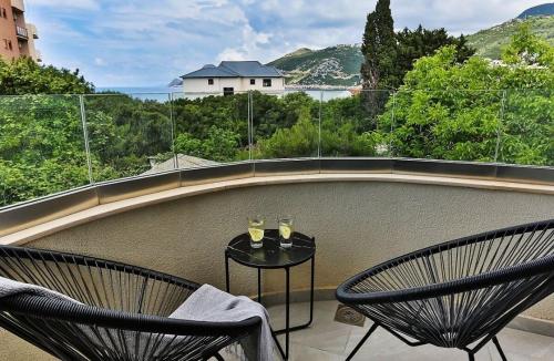 a balcony with two chairs and a table with wine glasses at Dobra Voda 10A in Dubrava