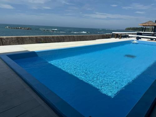 a blue swimming pool with the ocean in the background at MARINE-Q in Inami