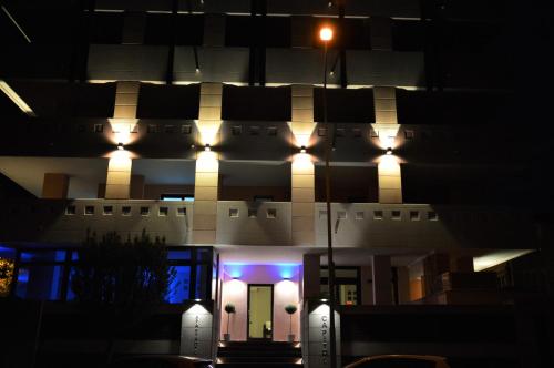 a building with lights on the front at night at Aparthotel Capitol in Grado