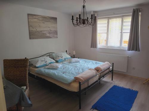 a bedroom with a bed in a room with a chandelier at Ferienwohnung Dießen Bierdorf - Holzacker in Dießen am Ammersee
