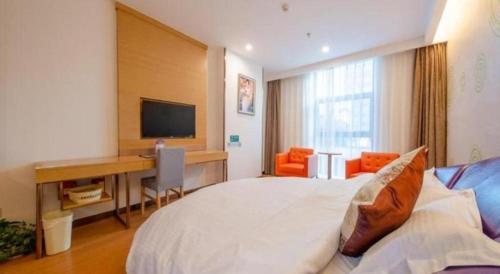 a bedroom with a bed and a desk and a television at GreenTree Inn Nantong University Industrial Expo City Express Hotel in Nantong