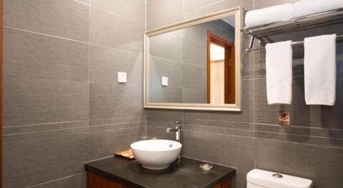 a bathroom with a sink and a mirror at James Joyce Coffetel Xian Dayanta Metro Station Branch in Xi'an