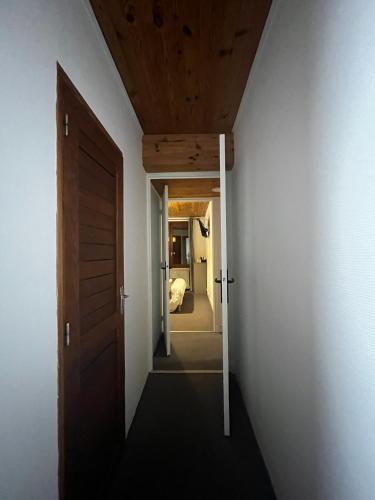a hallway leading to a bedroom with a door at Hôtel Au Feu De Bois in Autrans