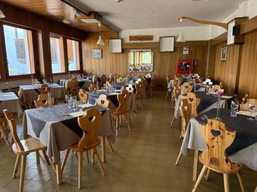 a dining room filled with tables and chairs at HG Hotel La Caminatha in Val di Zoldo