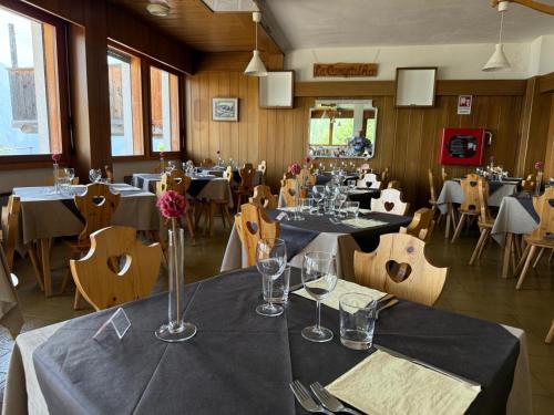 a dining room with tables and chairs and tablesktop at HG Hotel La Caminatha in Val di Zoldo