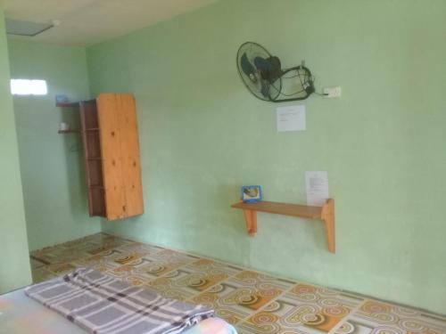 a room with a bed and a shelf on the wall at Bunda Homestay and Garden Warung 