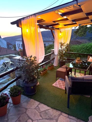 a patio with a table and chairs and an umbrella at VENUS GUESTHOUSE in Portariá