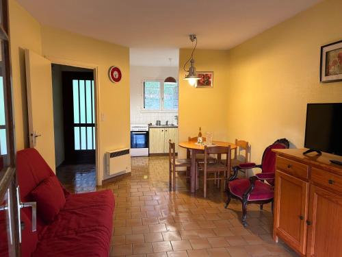 un salon avec un canapé et une table avec des chaises dans l'établissement bungalows les thuyas, à Eugénie-les-Bains