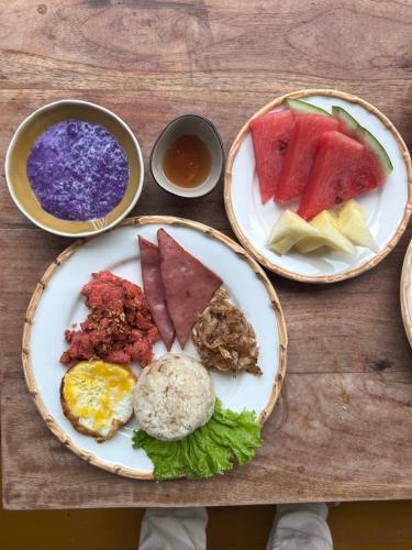 une table avec trois assiettes de nourriture dessus dans l'établissement Station One Beach Resort, à El Nido