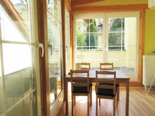 ハイデルベルクにあるFerienwohnungen Neckarblick - Heidelberg Altstadtのテーブルと椅子と窓のあるダイニングルーム