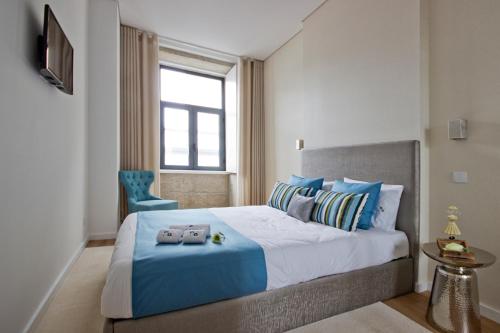 ポルトにあるOHH -Porto 4 you- Deluxe Apartment With Free Parkingのベッドルーム(青い枕の大型ベッド1台付)