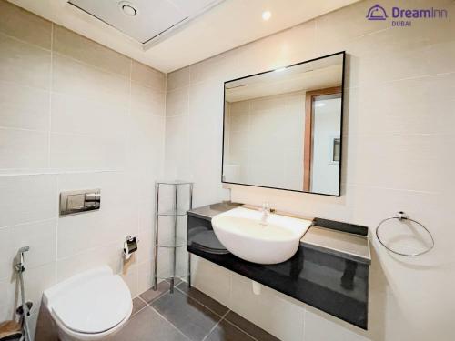 a bathroom with a sink and a toilet and a mirror at Dream Inn Apartments - Luxury 2 BR Mina Al Fajer - Harbor View - Al Fujairah in Rūl Ḑadnā