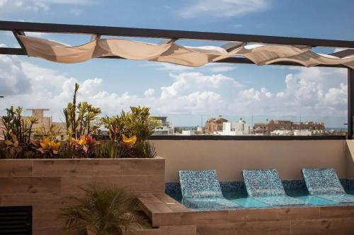 two chairs on a balcony with a view of the city at George Luxury Condo in Playa del Carmen