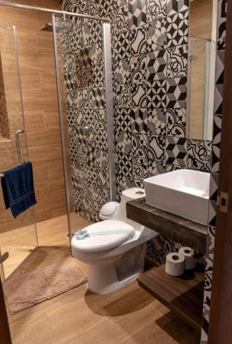 a bathroom with a toilet and a sink and a shower at George Luxury Condo in Playa del Carmen