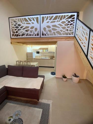 a living room with a couch and a staircase at ED Living in Orikum