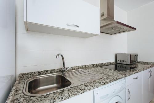 a kitchen with a sink and a microwave at Singular Virgenes in Seville