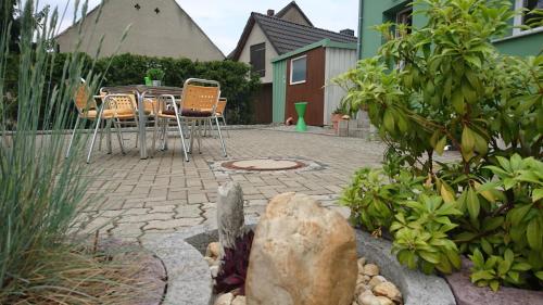 a patio with chairs and a table in a garden at Heidebistro in Commerau
