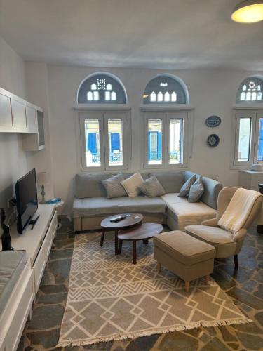 a living room with a couch and a tv at Sea views - Marble Palace - 2 floors in Tinos Town