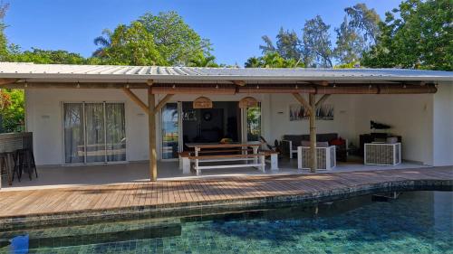 a pavilion with a wooden deck next to a pool at Villa Philibert in Riambel