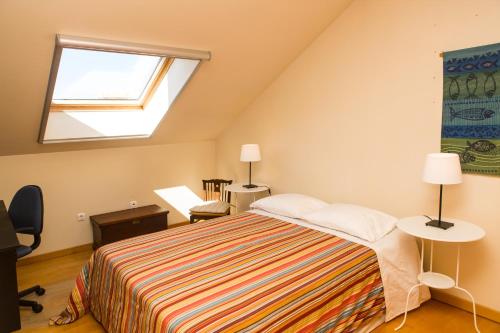Un dormitorio con una cama grande y una ventana en Casa Palheiro Amarelo da Biarritz, en Costa Nova