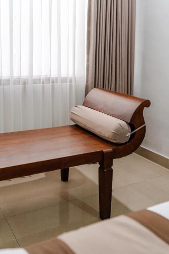 a bench with a pillow sitting on top of it at Dewi Sri Hotel in Legian