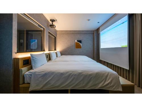 Un dormitorio con una cama grande con una pantalla grande. en LACER OKINAWA NAHA Tomarifutou - Vacation STAY 96911v, en Naha