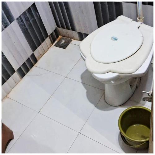 德瓦尔卡Hotel Yuvraj AC OR NON AC BOTH ROOM Dwarka Gujrat的浴室设有白色卫生间和绿色桶