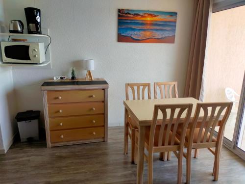 a dining room with a table and chairs and a dresser at T2 au calme résidence avec piscine - Les Hauts de Balaruc in Balaruc-les-Bains