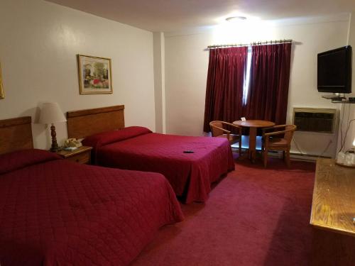 a hotel room with two beds and a table at Woonsocket Motor Inn in Woonsocket