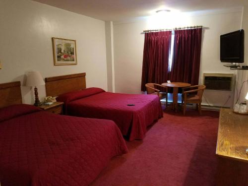 a hotel room with two beds and a table at Woonsocket Motor Inn in Woonsocket