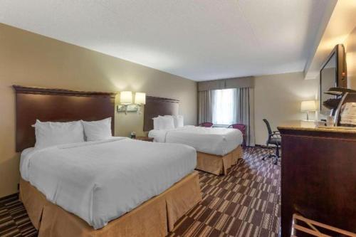 a hotel room with two beds and a television at Best Western Plus Orillia Hotel in Orillia