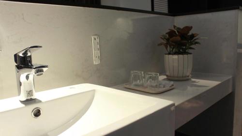 a bathroom sink with a faucet and glasses on a counter at An Bình homestay - Sapphire S2, Bến Đoan, Hạ Long, Quảng Ninh in Ha Long