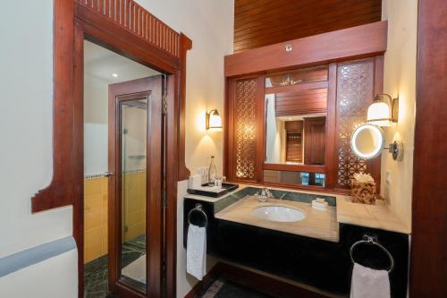 a bathroom with a sink and a mirror at The Leela Kovalam, A Raviz Hotel in Kovalam