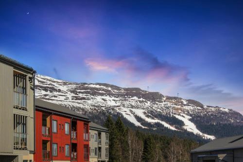 a snow covered mountain in the distance with houses and snow at NEW Scenic Family Stay in Tegefjäll Hike & Relax in Åre