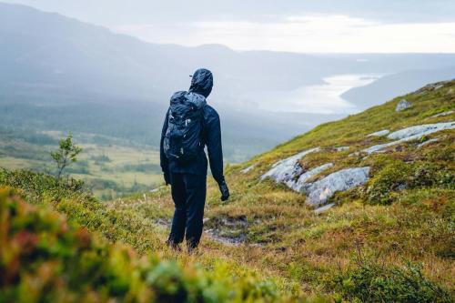 a person with a backpack standing on a hill at NEW Scenic Family Stay in Tegefjäll Hike & Relax in Åre