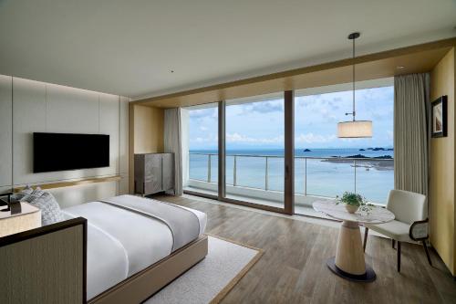 a bedroom with a large bed and a large window at Grand Ocean View Hotel Zhuhai in Zhuhai