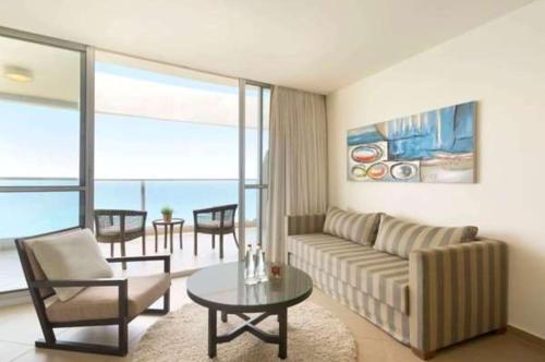 a living room with a couch and a table at Neve David Hotel in Netanya