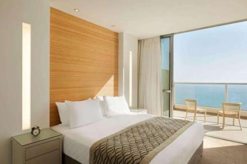 una camera con un grande letto e un balcone di Neve David Hotel a Netanya
