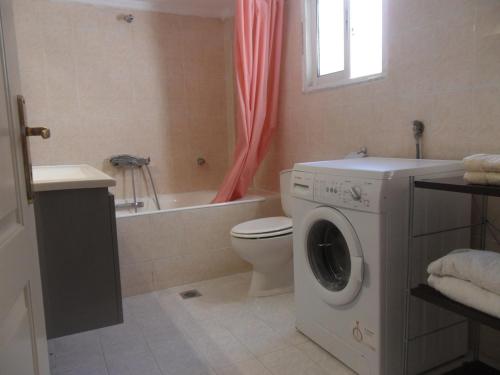 a bathroom with a washing machine and a toilet at Comfortable Thermi apartment near SKG Airport in Thérmi