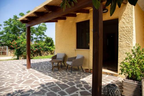a patio with two chairs and a pergola at Agriturismo La Genziana in Alghero