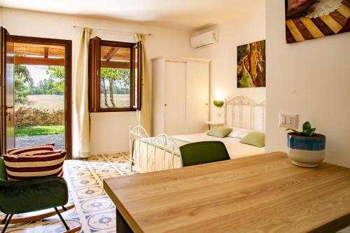 a bedroom with a bed and a table and chairs at Agriturismo La Genziana in Alghero