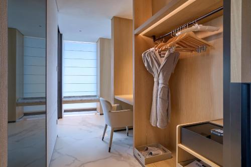 a walk in closet with a desk and a chair at Grand Ocean View Hotel Zhuhai in Zhuhai