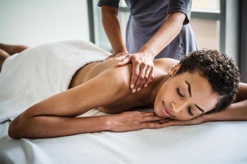a woman getting a massage from a man on a bed at Grand Hyatt Berlin in Berlin