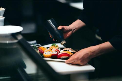 a person preparing a plate of food on a table at Grand Hyatt Berlin in Berlin